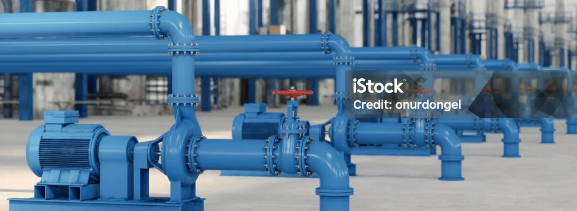 Rows of large blue industrial pipes and valves are shown, with a motor or pump attached in the foreground.